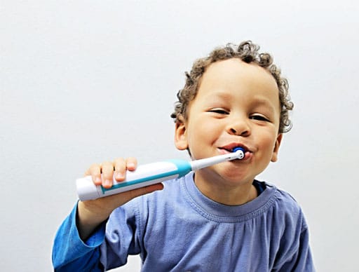 i bambini si divertono usando lo spazzolino elettrico